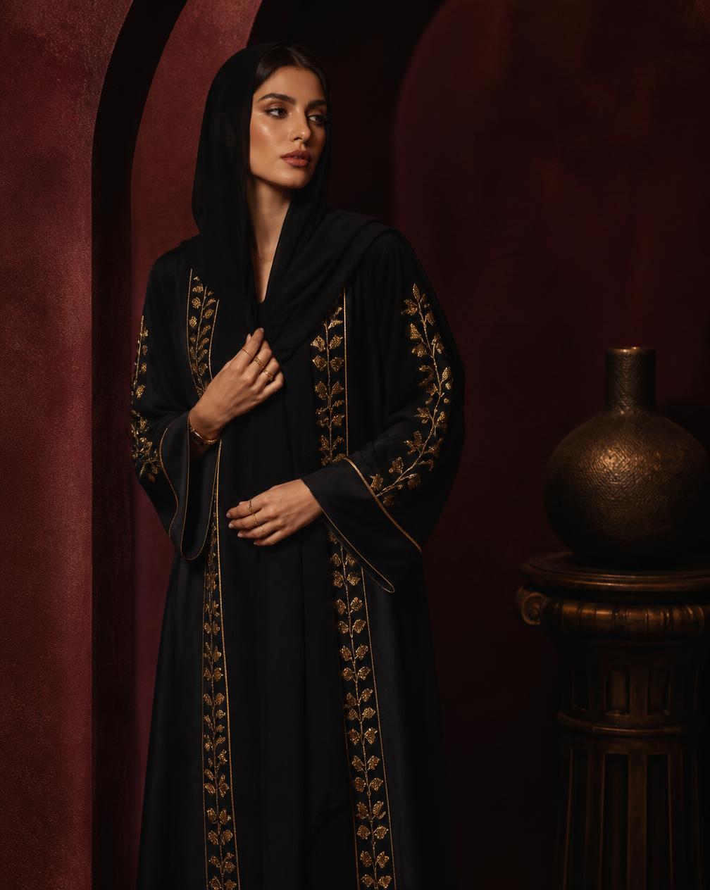 Emirati model wearing a black abaya with gold embroidery